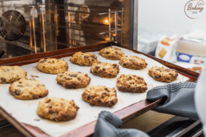 Freshly baked, golden-brown cookies with perfect round shape on a baking tray