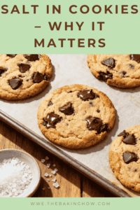 Flat lay of chocolate chip cookies on a baking tray with flaky sea salt sprinkled on top, styled for Pinterest with text overlay 'Salt in Cookies – Why It Matters