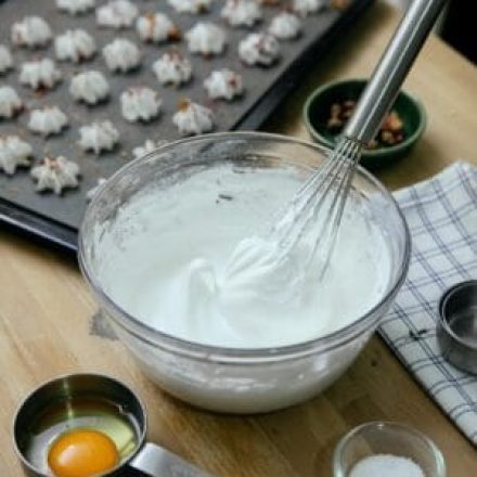 Image for about us, whisked glazing with cookies tray and eggs in cup on clean kitchen counter